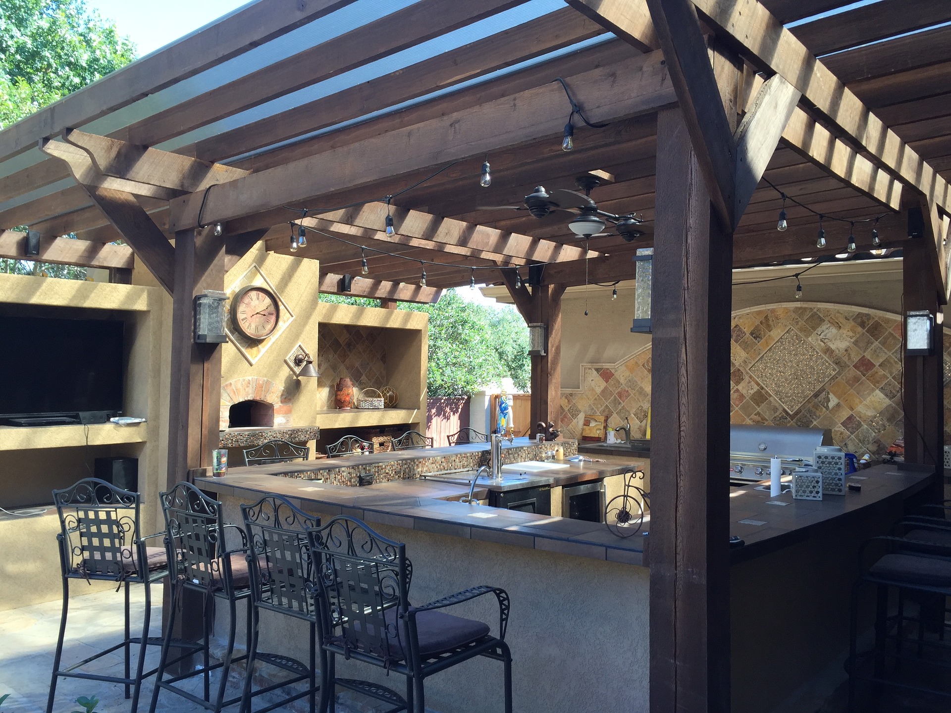 Une cuisine d'extérieur aménagée sous une pergola